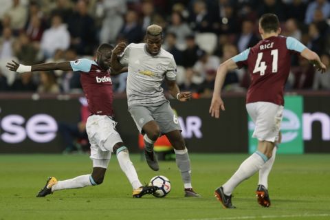 West Ham United's Cheikhou Kouyaté, left, takes the ball of Manchester United's Paul Pogba during the English Premier League soccer match between West Ham United and Manchester United at the London Stadium in London, Thursday, May 10, 2018. (AP Photo/Alastair Grant)