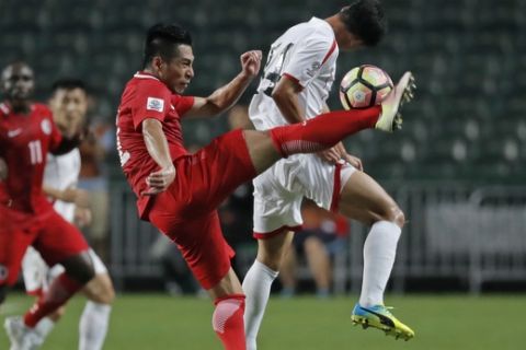 Hong Kong's Lee Chi Ho, left, fights for the ball against North Korea's Kang Kuk-chol, right, during the AFC Asian Cup 2019 qualification soccer match in Hong Kong, Tuesday, June 13, 2017. (AP Photo/Kin Cheung)