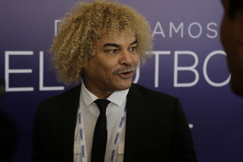 Former Colombian soccer star Carlos Valderrama talks to journalists upon his arrival to the symposium, "Let's discuss soccer" at the Conmebol Museum Hall in Luque, Paraguay, Wednesday, May 17, 2017. (AP Photo/Jorge Saenz)