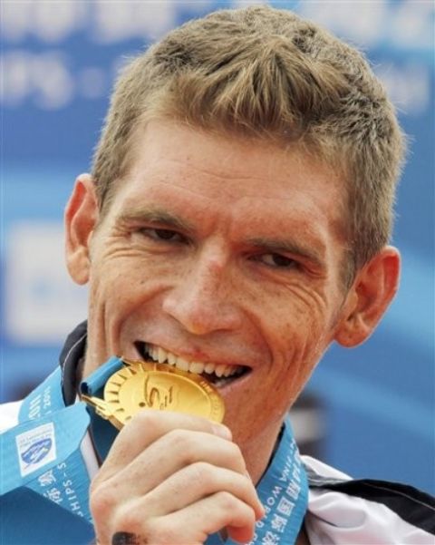 Greece's Spyros Gianniotis bites the gold medal after winning the men's 10km Open Water swimming event at the FINA Swimming World Championships at Jinshan Beach in Shanghai, China, Wednesday, July 20, 2011. The Greek swimmer finished in 1 hour, 54 minutes, 24.7 seconds. (AP Photo/Ng Han Guan)
