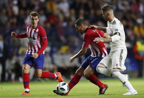 Atletico's Antoine Griezmann, left, watches Real Madrid's Sergio Ramos, right, challenging Atletico's Koke, center, during the UEFA Super Cup final soccer match between Real Madrid and Atletico Madrid at the Lillekula Stadium in Tallinn, Estonia, Wednesday, Aug. 15, 2018. (AP Photo/Pavel Golovkin)