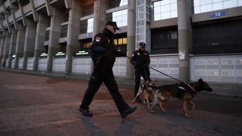 Police officers patrol with dogs outside the Santiago Bernabeu stadium ahead of the Copa Libertadores Final between River Plate and Boca Juniors in Madrid, Sunday, Dec. 9, 2018. (AP Photo/Manu Fernandez)