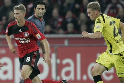 Leverkusen's Lars Bender, centre, and his brother Dortmund's Sven Bender, right, challenge  for the ball during the German first division Bundesliga soccer match between Bayer Leverkusen and Borussia Dortmund in Leverkusen, Germany, Friday, Oct. 23, 2009. (AP Photo/Hermann J. Knippertz)  ** NO MOBILE USE UNTIL 2 HOURS AFTER THE MATCH, WEBSITE USERS ARE OBLIGED TO COMPLY WITH DFL-RESTRICTIONS, SEE INSTRUCTIONS FOR DETAILS **