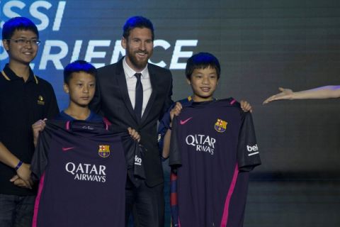 Barcelona's Lionel Messi poses for photos with young footballers from a Chinese rural school during an event to launch the establishment of Messi Experience Park in Beijing, China, Thursday, June 1, 2017. The park to be completed within 2 years in eastern China will be based on football culture and promote the sports amongst China's youths. (AP Photo/Ng Han Guan)