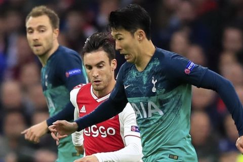 Tottenham's Son Heung-Min, right, runs with the ball followed by Ajax's Nicolas Tagliafico during the Champions League semifinal second leg soccer match between Ajax and Tottenham Hotspur at the Johan Cruyff ArenA in Amsterdam, Netherlands, Wednesday, May 8, 2019. (AP Photo/Peter Dejong)