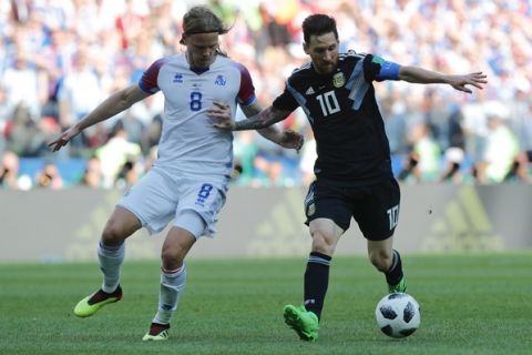 Argentina's Lionel Messi, right, challenges for the ball with Iceland's Birkir Bjarnason during the group D match between Argentina and Iceland at the 2018 soccer World Cup in the Spartak Stadium in Moscow, Russia, Saturday, June 16, 2018. (AP Photo/Ricardo Mazalan)