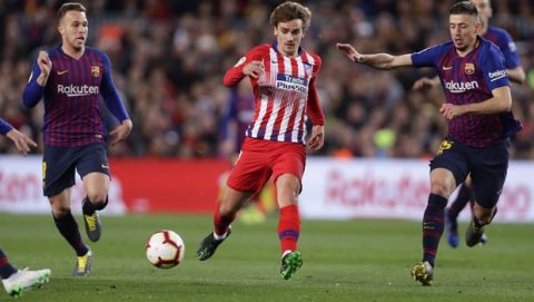 Atletico forward Antoine Griezmann, center, vies for the ball with Barcelona midfielder Arthur, left, and Barcelona defender Clement Lenglet, right, during a Spanish La Liga soccer match between FC Barcelona and Atletico Madrid at the Camp Nou stadium in Barcelona, Spain, Saturday April 6, 2019. (AP Photo/Manu Fernandez)