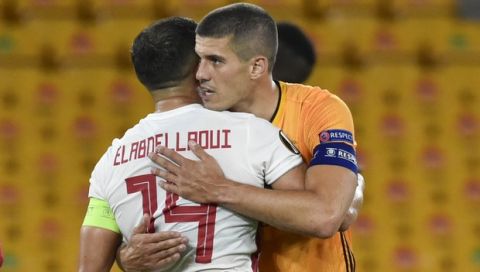 Wolverhampton Wanderers' Conor Coady, right, embraces Olympiakos' Omar Elabdellaoui after the Europa League round of 16 second leg soccer match between Wolves and Olympiakos at Molineux Stadium in Wolverhampton, England, Thursday, Aug. 6, 2020. (AP Photo/Rui Vieira)