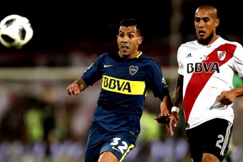Boca Juniors' Carlos Tevez, left, fights for the ball with River Plate's Jonatan Maidana during the Supercopa Argentina final match in Mendoza, Argentina, Wednesday, March 14, 2018.(AP Photo/Marcelo Ruiz)