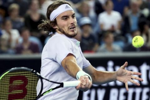 Stefanos Tsitsipas of Greece makes a forehand return to Italy's Salvatore Caruso during their first round singles match at the Australian Open tennis championship in Melbourne, Australia, Monday, Jan. 20, 2020. (AP Photo/Dita Alangkara)
