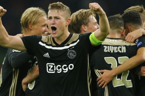 Ajax's captain Matthijs de Ligt clenches his fists as his teammates join in celebrating their 1-0 victory during a Group E Champions League soccer match between Ajax and Benfica at the Johan Cruyff ArenA in Amsterdam, Netherlands, Tuesday, Oct. 23, 2018. (AP Photo/Peter Dejong)