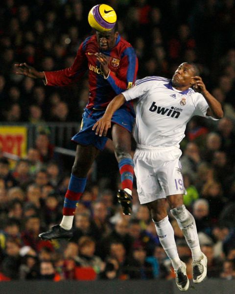 FC Barcelona Yaya Toure, from Ivory Coast, left, jumps for the ball against Real Madrid Brazilian player Julio Baptista during their Spanish League match in Barcelona, Spain, Sunday Dec. 23, 2007. (AP Photo/Bernat Armangue)