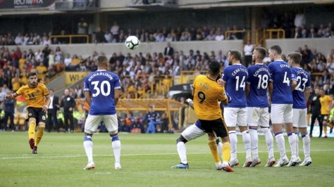 Wolverhampton Wanderers' Ruben Neves (left) scores his side's first goal of the game against Everton during their English Premier League soccer match at Molineux in Wolverhampton, England, Saturday Aug. 11, 2018. (Nick Potts/PA via AP)