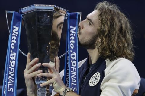 Stefanos Tsitsipas of Greece kisses the and holds up the trophy and celebrates after defeating Austria's Dominic Thiem in the final of the ATP World Finals tennis match at the O2 arena in London, Sunday, Nov. 17, 2019.(AP Photo/Kirsty Wigglesworth)
