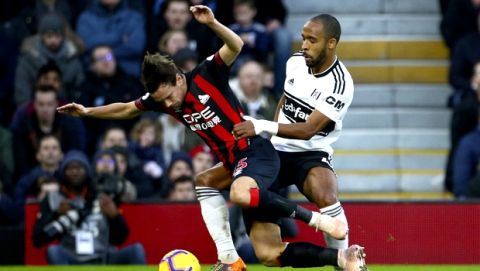 Huddersfield Town's Chris Lowe, left, and Fulham's Denis Odoi in action during their English Premier League soccer match at Craven Cottage in London, Saturday Dec. 29, 2018. (Yui Mok/PA via AP)
