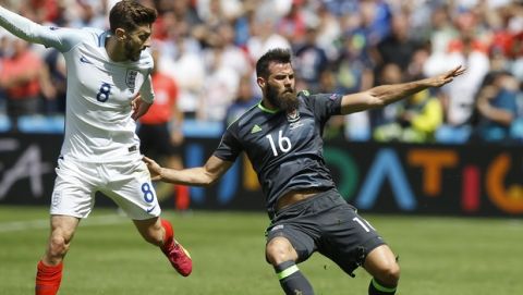 Englands Adam Lallana , left, vies for the ball with Wales Joe Ledley  during the Euro 2016 Group B soccer match between England and Wales at the Bollaert stadium in Lens, France, Thursday, June 16, 2016. (AP Photo/Kirsty Wigglesworth)