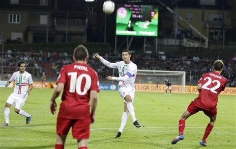 Portugal's Cristiano Ronaldo, right, shoots against Luxembourg's Ben Payal, left, and Lars Gerson, right, during their World Cup 2014 Group F qualifying soccer match in Luxembourg, Friday, Sept. 7, 2012. (AP Photo/Virginia Mayo)