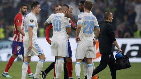 Teammates hugs Marseille's Dimitri Payet, center, as he walks off the pitch after sustaining an injury during the Europa League Final soccer match between Marseille and Atletico Madrid at the Stade de Lyon in Decines, outside Lyon, France, Wednesday, May 16, 2018. (AP Photo/Francois Mori)
