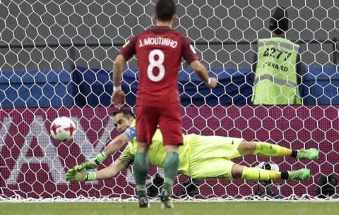 Chile goalkeeper Claudio Bravo stops a penalty from Portugal's Joao Moutinho during the Confederations Cup, semifinal soccer match between Portugal and Chile, at the Kazan Arena, Russia, Wednesday, June 28, 2017. (AP Photo/Ivan Sekretarev)