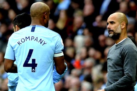 Manchester City manager Josep Guardiola, right, speaks with Vincent Kompany during the English Premier League soccer match between Manchester City and Burnley at Etihad stadium in Manchester, England, Saturday, Oct. 20, 2018. (AP Photo/Rui Vieira)