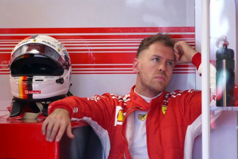 Ferrari driver Sebastian Vettel of Germany sits in his garage during the first practice session at the Australian Formula One Grand Prix in Melbourne, Friday, March 23, 2018. The first race of the 2018 seasons is on Sunday. (AP Photo/Rick Rycroft)
