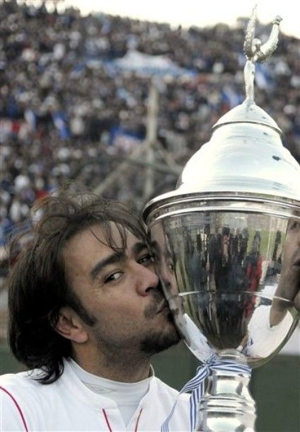 Uruguay's Nacional's player Alvaro Recoba kisses his team's trophy at the end of the Uruguayan league final soccer match against Defensor Sporting in Montevideo, Uruguay, Saturday, June 16, 2012. (AP Photo/Matilde Campodonico)