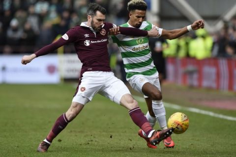 Hearts Michael Smith, left, tackles Celtic's Scott Sinclair during their Scottish Premiership soccer match at Tynecastle Stadium in Edinburgh, Scotland, Sunday Dec. 17, 2017.  Celtics record 69-match unbeaten run in Scottish soccer ended with a surprise thrashing on Sunday, when they lost 4-0 to Hearts, for their first defeat in any domestic competition since May 2016.(Ian Rutherford/PA via AP)
