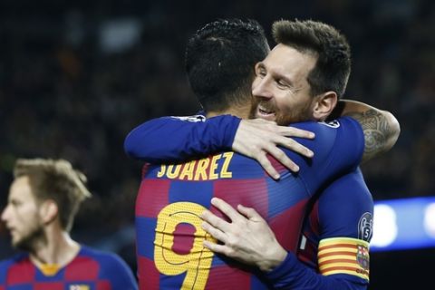 Barcelona's Luis Suarez is congratulated by Lionel Messi, right, after scoring the opening goal during a Champions League soccer match Group F between Barcelona and Dortmund at the Camp Nou stadium in Barcelona, Spain, Wednesday, Nov. 27, 2019. (AP Photo/Joan Monfort)