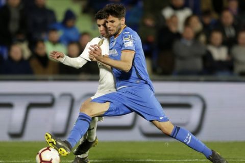 Real Madrid's Brahim Diaz, left, fights for the ball with Getafe's Leandro Daniel Cabrera during a Spanish La Liga soccer match between Getafe and Real Madrid at the Alfonso Perez stadium in Getafe, Spain, Thursday, April 25, 2019. (AP Photo/Bernat Armangue)