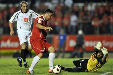 Brazilian former football star Ronaldo (L) vies for the ball with goalkeeper Vitor (R) during a charity football match organized by former Brazilian national team player Zico, at Morumbi stadium in Sao Paulo, Brazil, on December 28, 2011. AFP PHOTO / Nelson ALMEIDA (Photo credit should read NELSON ALMEIDA/AFP/Getty Images)