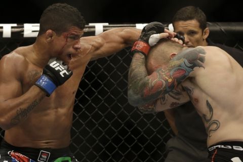 Gilbert Burns, left, punches Andreas Stahl during a welterweight mixed martial arts bout at a UFC on Fox event in San Jose, Calif., Saturday, July 26, 2014. Burns won by unanimous decision. (AP Photo/Jeff Chiu)
