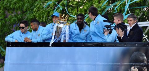 Manchester City players and their manager, Roberto Mancin (R) stand on an open topped bus as they celebrate becoming English Premier League champions in a parade leaving from Mancheter Town Hall in Manchester, northwest England, on May 14, 2012. Manchester City beat their rivals Manchester United on goal difference to be crowned champions on the final day of the season with a 3-2 victory over Queens Park Rangers. AFP PHOTO/PAUL ELLISPAUL ELLIS/AFP/GettyImages