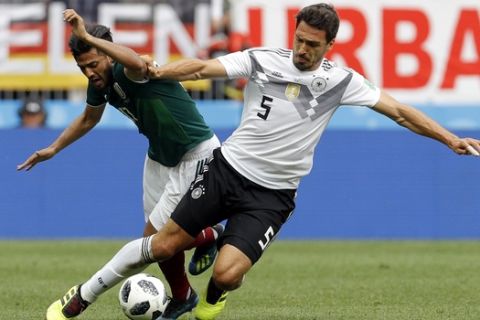 Mexico's Carlos Vela, left, fights for the ball with Germany's Mats Hummels during the group F match between Germany and Mexico at the 2018 soccer World Cup in the Luzhniki Stadium in Moscow, Russia, Sunday, June 17, 2018. (AP Photo/Victor R. Caivano)