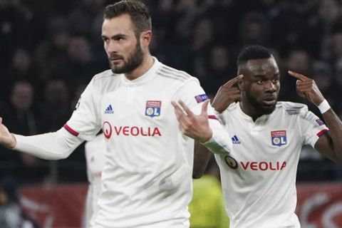 Lyon's Maxwel Cornet, right, gestures as he celebrates with teammate Lucas Tousart, left, who scored his side's first goal during a round of sixteen, first leg, soccer match between Lyon and Juventus at the at the Lyon Olympic Stadium in Decines, outside Lyon, France, Wednesday, Feb. 26, 2020. (AP Photo/Laurent Cipriani)