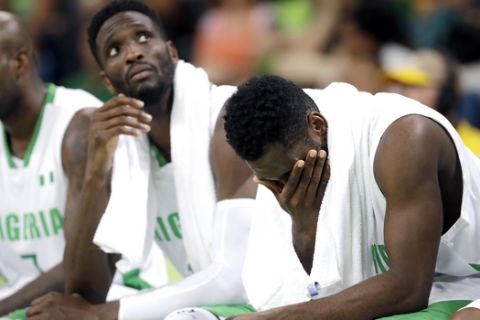 Nigeria's Al-Farouq Aminu, left, Ekene Ibekwe, center, and Nigeria's Chamberlain Oguchi, right, sit on the bench during the final moments of a men's basketball game against Brazil at the 2016 Summer Olympics in Rio de Janeiro, Brazil, Monday, Aug. 15, 2016. (AP Photo/Eric Gay)