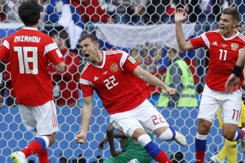 Russia's Artyom Dzyuba, center, celebrates after scoring his side's third goal during the group A match between Russia and Saudi Arabia which opens the 2018 soccer World Cup at the Luzhniki stadium in Moscow, Russia, Thursday, June 14, 2018. (AP Photo/Hassan Ammar)