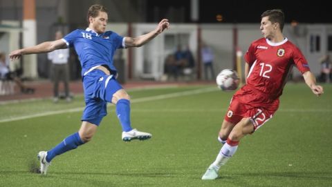 Liechtenstein's Nicolas Hasler, left and Gibraltar's Jayce Olivero challenge for the ball during the UEFA Nations League soccer match between Gibraltar and Liechtenstein at the Victoria Stadium in Gibraltar, Tuesday Oct. 16, 2018. (AP Photo/Marcus Moreno)