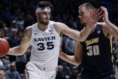 Xavier forward Zach Hankins (35) drives against Toledo center Luke Knapke (30) during the first half of a first round basketball game of the National Invitation Tournament, Wednesday, March 20, 2019, in Cincinnati. (AP Photo/Gary Landers)