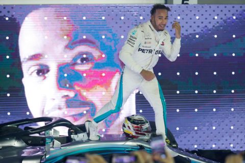 Mercedes driver Lewis Hamilton of Britain celebrates on his car after winning the Singapore Formula One Grand Prix at the Marina Bay City Circuit in Singapore, Sunday, Sept. 16, 2018. (AP Photo/Vincent Thian)