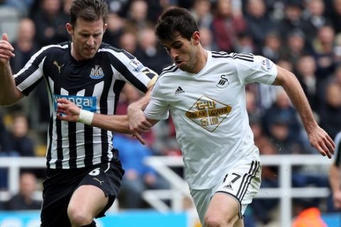 Swansea City's Nelson Oliveira, right, vies for the ball with Newcastle United's Mike Williamson, left, during the English Premier League soccer match between Newcastle United and Swansea City at St James' Park, Newcastle, England, Saturday, April 25, 2015. (AP Photo/Scott Heppell)
