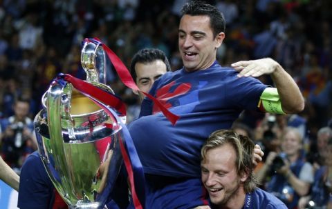 Barcelona's Xavi Hernandez is carried by his team-mates as he holds the trophy after the Champions League final soccer match between Juventus Turin and FC Barcelona at the Olympic stadium in Berlin Saturday, June 6, 2015. Barcelona won the match 3-1. (AP Photo/Luca Bruno)