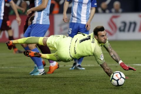 Malaga's goalkeeper Roberto Jimenez tries to reach the ball during a Spanish La Liga soccer match between Malaga and Barcelona in Malaga, Spain, Saturday, March 10, 2018. (AP Photo/M.Pozo)