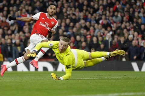Arsenal's Pierre-Emerick Aubameyang, left, scores his side's second goal as Everton's goalkeeper Jordan Pickford fails to save the ball during the English Premier League soccer match between Arsenal and Everton at Emirates stadium in London, Sunday, Feb. 23, 2020. (AP Photo/Kirsty Wigglesworth)