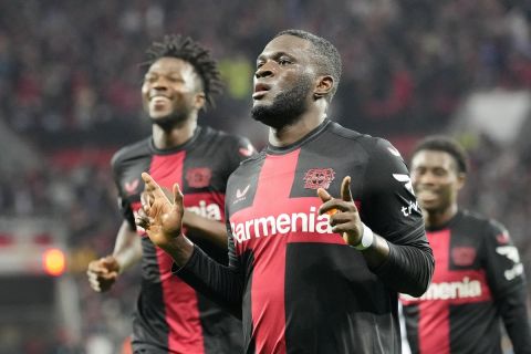 FILE - Leverkusen's Victor Boniface, center, celebrates with teammate Edmond Tapsoba, left, after scoring during the Europa League Group H soccer match between Bayer Leverkusen and Qarabag at the BayArena in Leverkusen, Germany, on Oct. 26, 2023. Bayer Leverkusen said Tuesday Jan. 9, 2024, Nigeria forward Victor Boniface has been ruled out of the Africa Cup of Nations with a thigh injury and has already returned to Germany. (AP Photo/Martin Meissner, File)