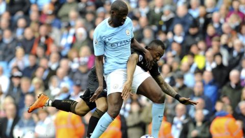 Manchester City's Yaya Toure, left, and Swansea's Jordan Ayew battle for the ball during the English Premier League soccer match between Manchester City and Swansea City at Etihad stadium in Manchester, England, Sunday, April 22, 2018. (AP Photo/Rui Vieira)