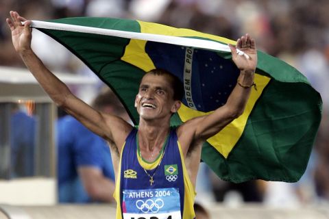 Brazil's Vanderlei Lima holds a Brazilian flag as he celebrates after he finished third in the men's marathon race in the last day of the 2004 Olympic Games in the Panathenian Stadium in Athens, Sunday Aug. 29, 2004. Italy's Stefano Baldini finished first and won the gold medal. (AP Photo/Diether Endlicher)