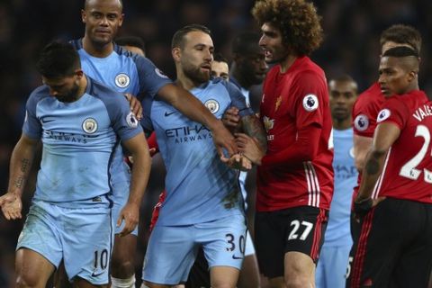 Manchester United's Marouane Fellaini, center, argues with Manchester City's Sergio Aguero, left, during the English Premier League soccer match between Manchester City and Manchester United at the Etihad Stadium in Manchester, England,Thursday, April 27, 2017.(AP Photo/Dave Thompson)