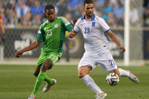 CHESTER, PA - JUNE 3:  Panagiotis Tachtsidis #23 of Greece kicks the ball away from Michael Uchebo #25 of Nigeria during an international friendly match at PPL Park on June 3, 2014 in Chester, Pennsylvania. The match ended in a tie, 0-0. (Photo by Drew Hallowell/Getty Images)