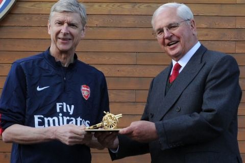 ST ALBANS, ENGLAND - MARCH 21:  Chairman Sir Chips Keswick presents Arsene Wenger with a gold cannon to commemorate his 1000th game as Arsenal manager at London Colney on March 21, 2014 in St Albans, England.  (Photo by Stuart MacFarlane/Arsenal FC via Getty Images)