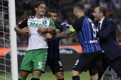 Inter Milan's Rafinha, 2nd right, holds Sassuolo's Mauricio Lemos, left, during the Serie A soccer match between Inter Milan and Sassuolo at the San Siro stadium in Milan, Italy, Saturday, May 12, 2018. (AP Photo/Luca Bruno)